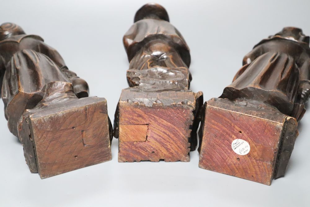 A set of three 19th century Dutch walnut figures of puritans, height 34cm